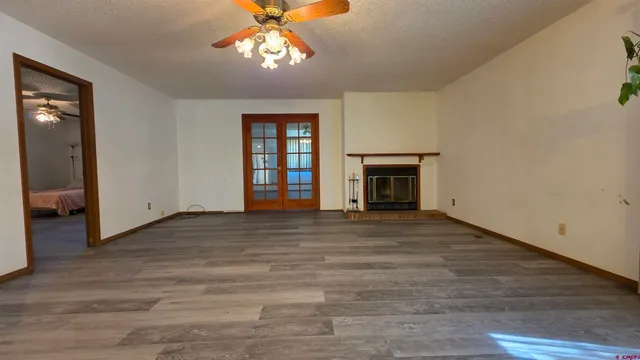 an empty room with wooden floor chandelier and entryway