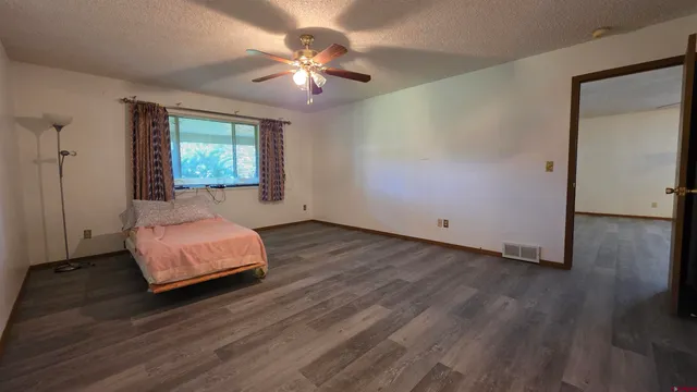 a spacious bedroom with a bed and a chandelier