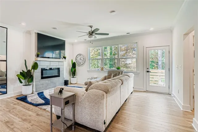 a living room with furniture a flat screen tv and a large window