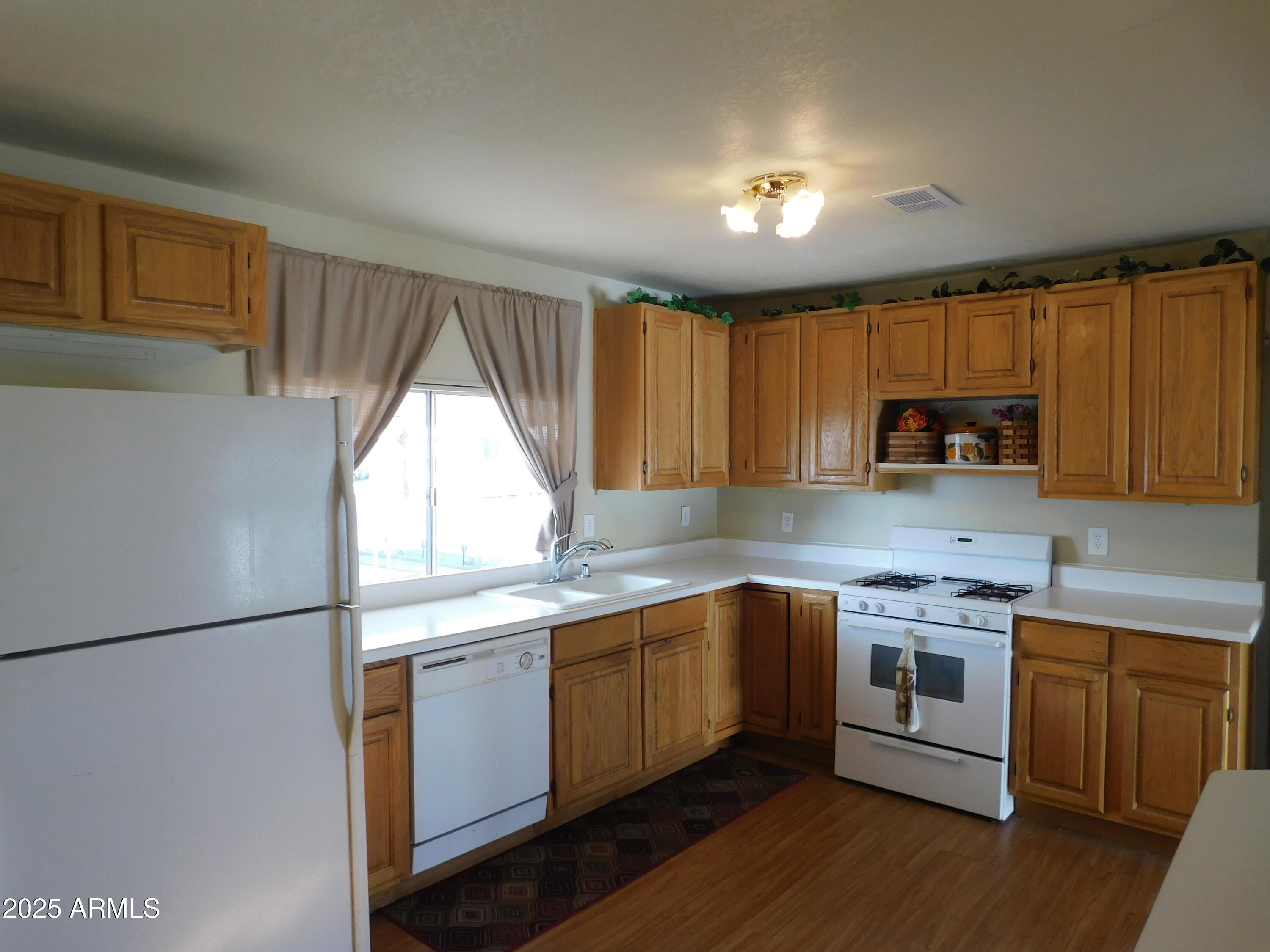 15802 South Gilbert Road, Unit 58 Chandler, AZ 85225 - Photo 7 of 21 a kitchen with stainless steel appliances granite countertop wooden cabinets a stove a sink and a refrigerator