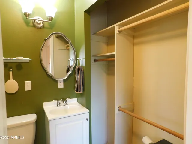 a bathroom with a sink mirror vanity and toilet