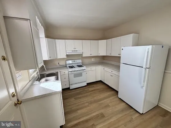 a kitchen with stainless steel appliances a refrigerator sink and white cabinets