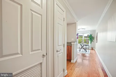 a view of a hallway with wooden floor windows and a livingroom