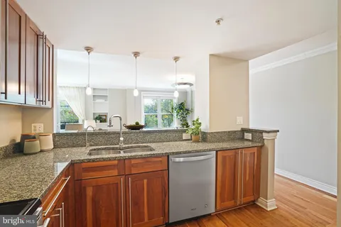 a kitchen with granite countertop a sink a counter space appliances and cabinets