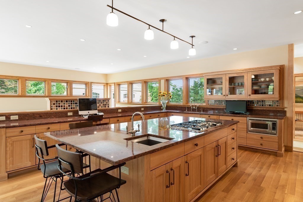130 Farm Street Dover, MA 02030 - Photo 11 of 39 a kitchen with stainless steel appliances granite countertop a stove top oven a sink dishwasher and chairs with wooden floor
