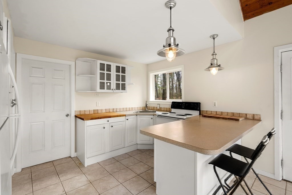 130 Farm Street Dover, MA 02030 - Photo 31 of 39 a kitchen with a sink a stove and chairs