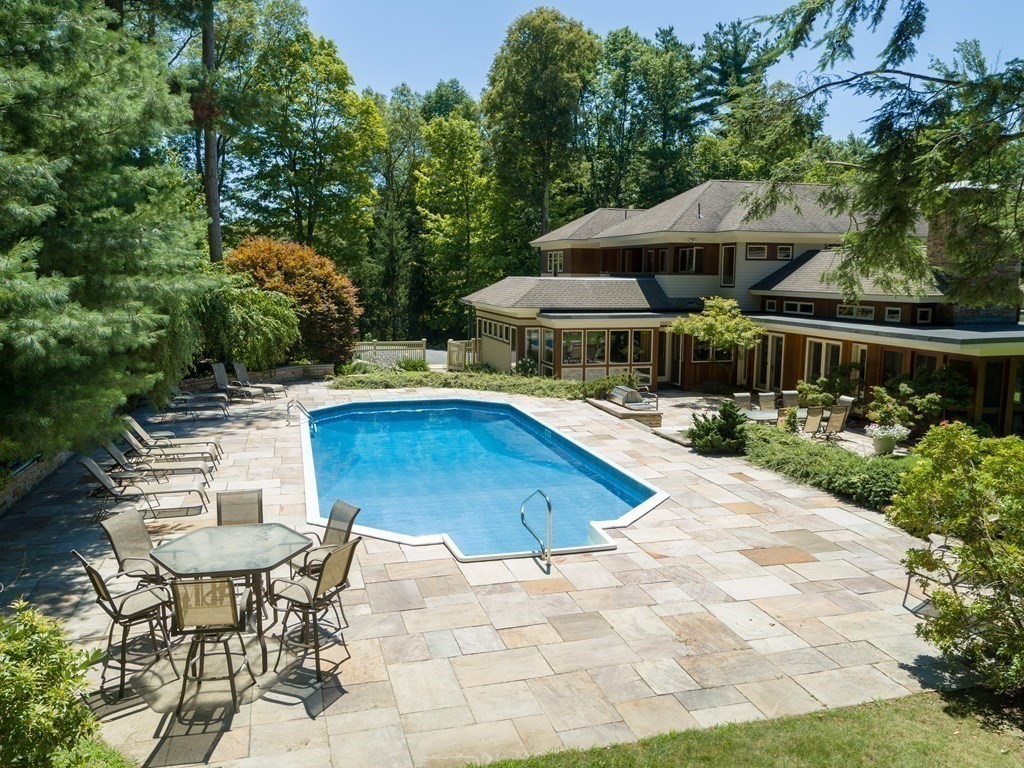 130 Farm Street Dover, MA 02030 - Photo 5 of 39 a view of pool with table and chairs under an umbrella