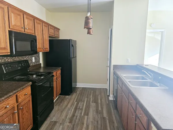 a kitchen with stainless steel appliances granite countertop a sink refrigerator and microwave