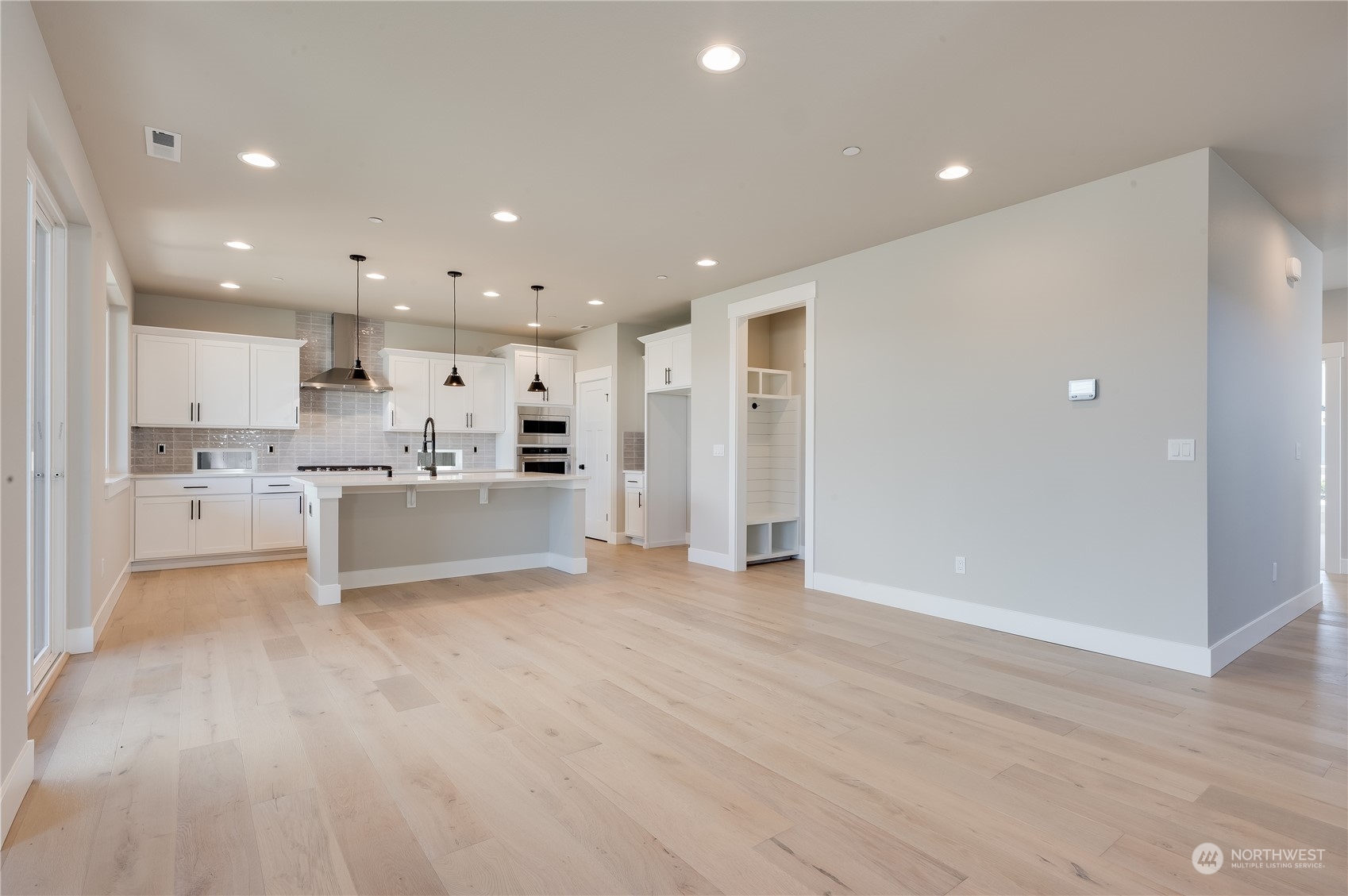 4433 244th Street Southeast, Unit LOT02 Bothell, WA 98021 - Photo 11 of 40 a view of kitchen with kitchen island a sink white cabinets and stainless steel appliances