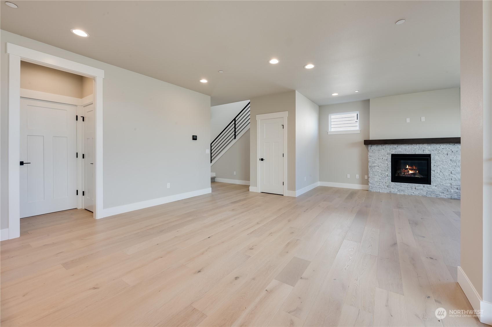 4433 244th Street Southeast, Unit LOT02 Bothell, WA 98021 - Photo 6 of 40 an empty room with wooden floor a fireplace and a window