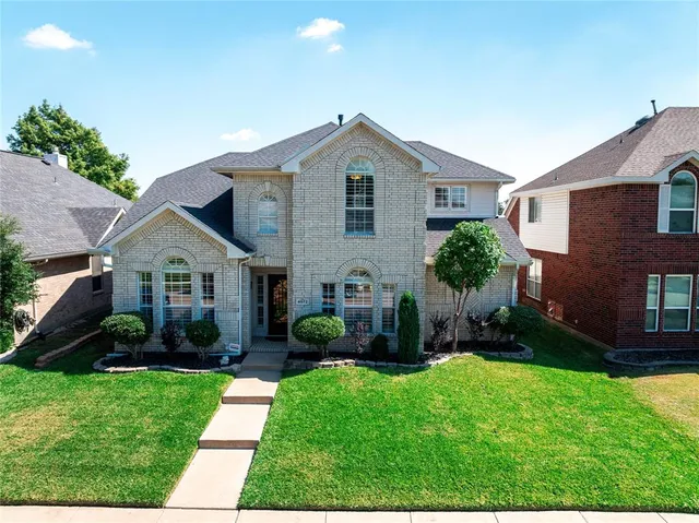 a front view of a house with a garden and plants