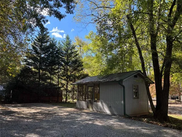 a view of house with yard and tree in front of it