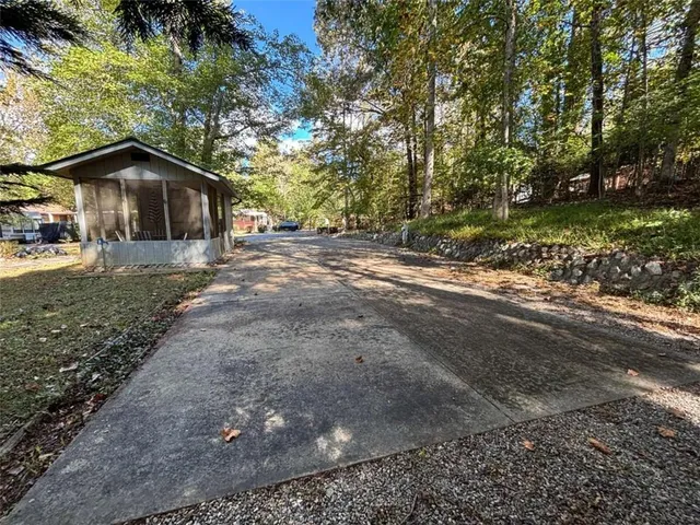a view of a house with a yard and large tree