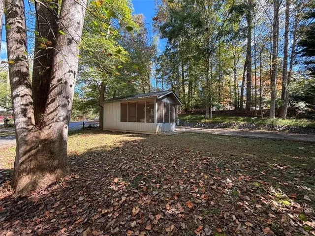 a view of a house with backyard and trees