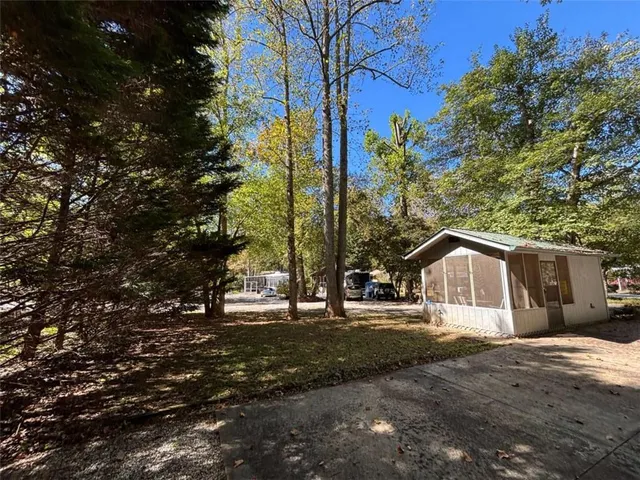 a view of a park with large trees and a wooden fence