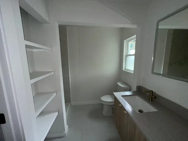 a bathroom with a sink toilet and window