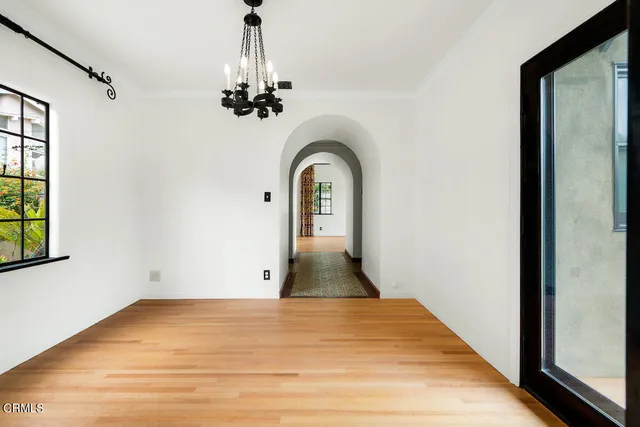 a view of empty room with window and wooden floor