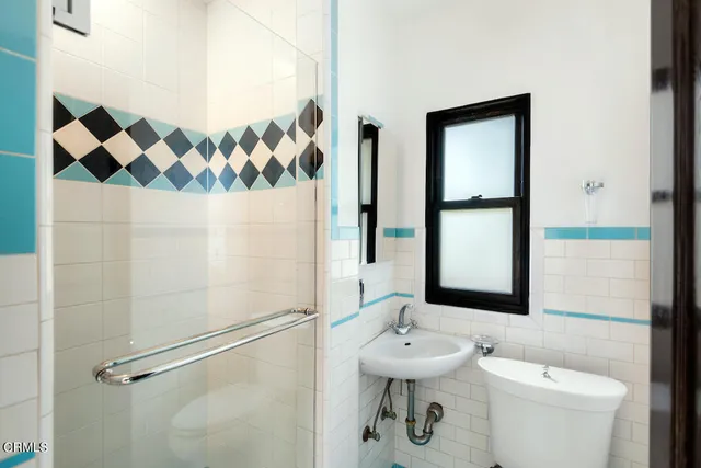 a bathroom with a sink and mirror with toilet