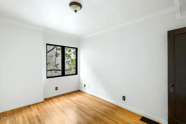 a view of a room that has a window and wooden floor