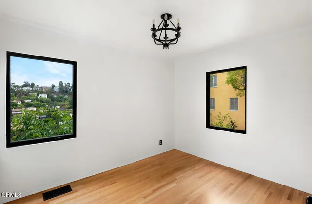 a view of a small space with wooden floor and a window
