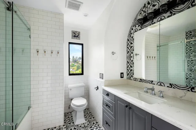 a bathroom with a toilet sink and mirror