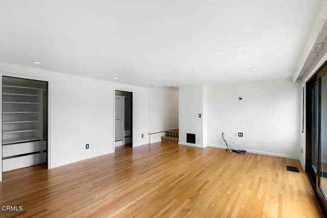 a view of empty room with wooden floor