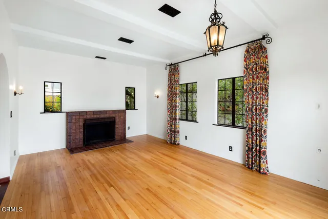 a view of empty room with fireplace and wooden floor