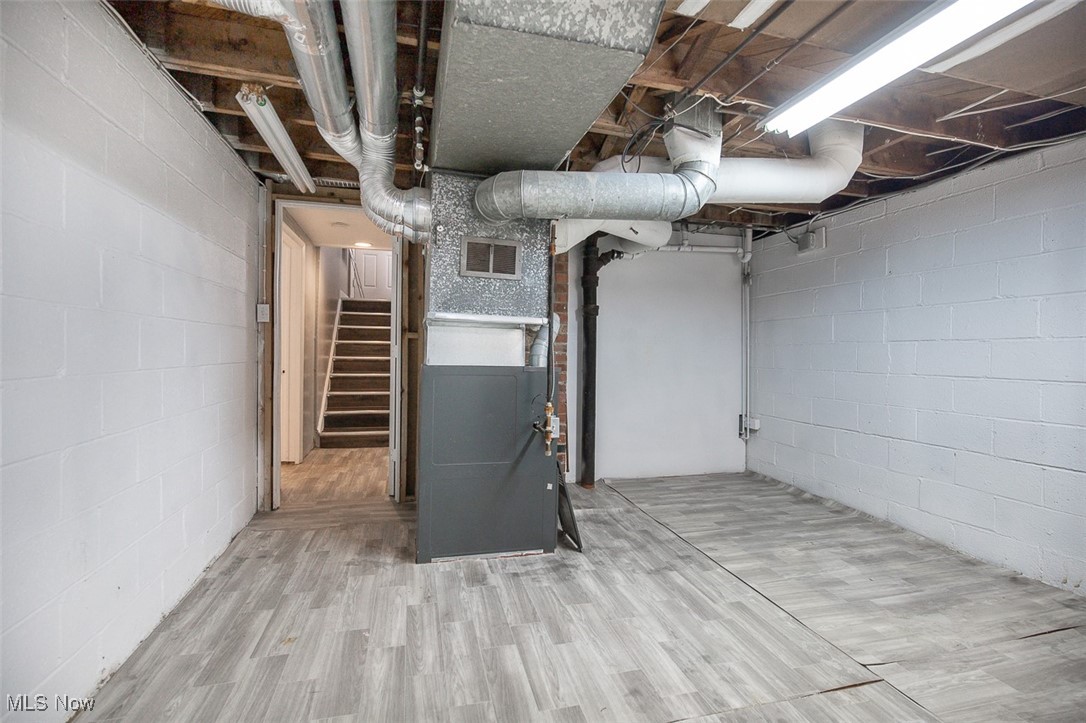 12328 Granger Road Cleveland, OH 44125 - Photo 33 of 37 Unfinished basement featuring heating unit, stairway, and wood finished floors