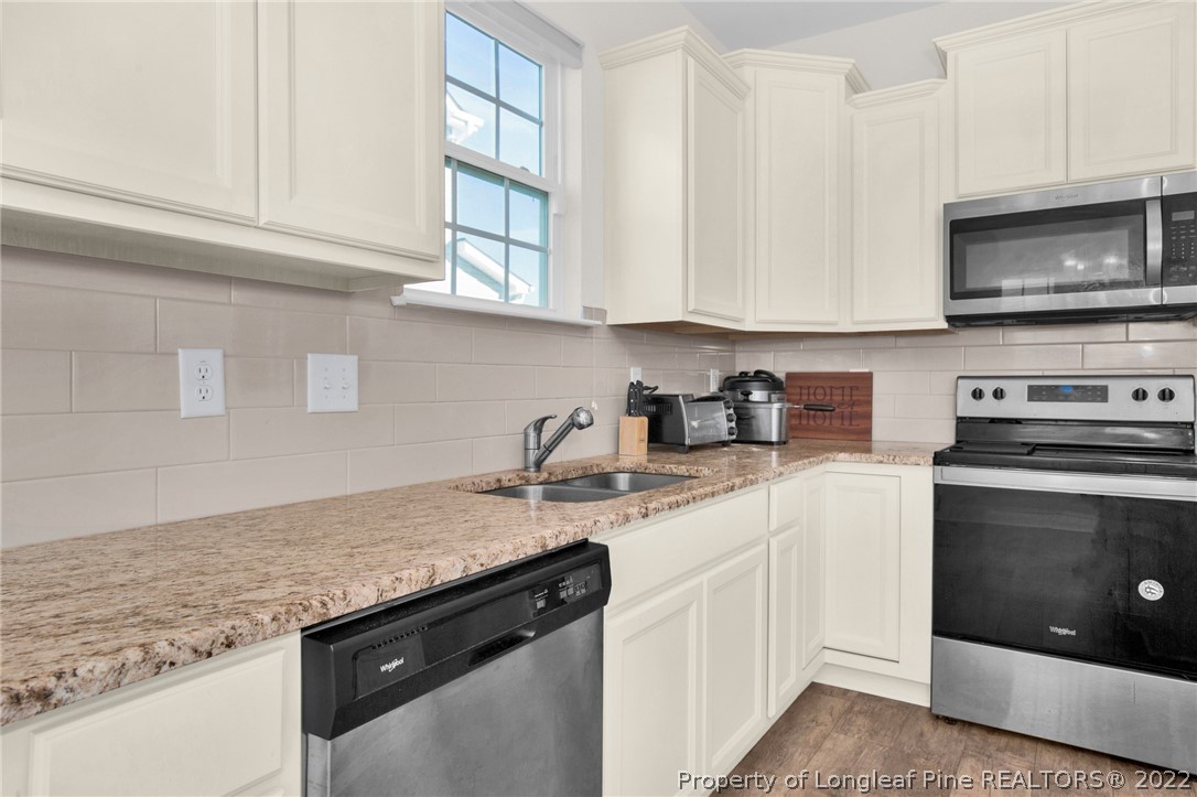 126 Verdmont Drive Raeford, NC 28376 - Photo 12 of 30 a kitchen with stainless steel appliances granite countertop a sink a stove and a microwave