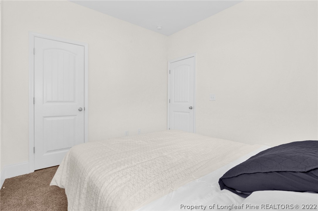 126 Verdmont Drive Raeford, NC 28376 - Photo 18 of 30 a bedroom with a bed and a chair