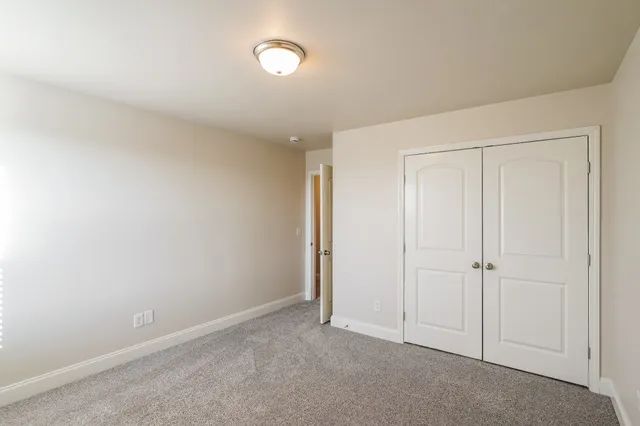 an empty room with white cabinet and closet