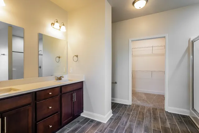 a spacious bathroom with a double vanity sink and mirror