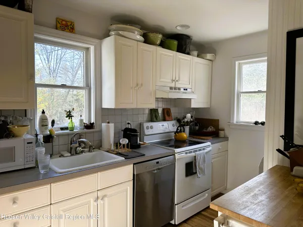 a kitchen with white cabinets and white appliances