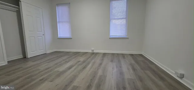 a view of a room that has wooden floor and a window