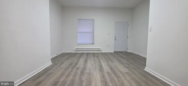 a view of a room with wooden floor and window