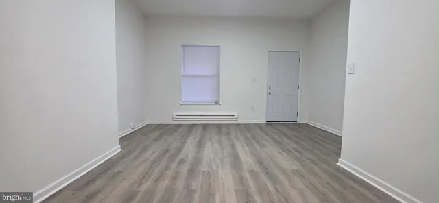 a view of a room with wooden floor and window