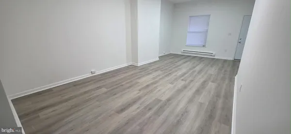 a view of an empty room with wooden floor