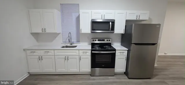 a kitchen with granite countertop white cabinets and stainless steel appliances