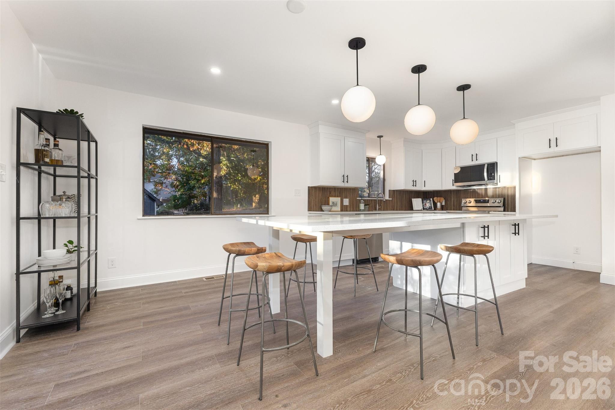 1184 Molokai Drive Fort Mill, SC 29708 - Photo 11 of 35 a kitchen with stainless steel appliances kitchen island granite countertop a stove a sink dishwasher and white cabinets with wooden floor
