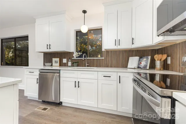 a kitchen with white cabinets and white appliances