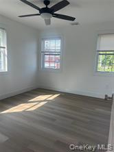 152 South Country Road, Unit B Bellport, NY 11713 - Photo 7 of 8 a view of empty room with wooden floor and fan