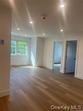 152 South Country Road, Unit B Bellport, NY 11713 - Photo 8 of 8 a view of an empty room with wooden floor and a window