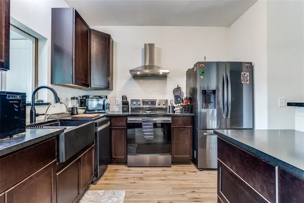 a kitchen with stainless steel appliances granite countertop a sink stove and refrigerator
