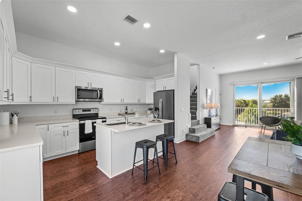 5730 Biscayne Court, Unit 6 New Port Richey, FL 34652 - Photo 8 of 55 a kitchen with stainless steel appliances a stove a refrigerator a sink a stove top oven a dining table and chairs