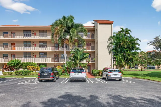 a front view of a house with a yard and potted plants