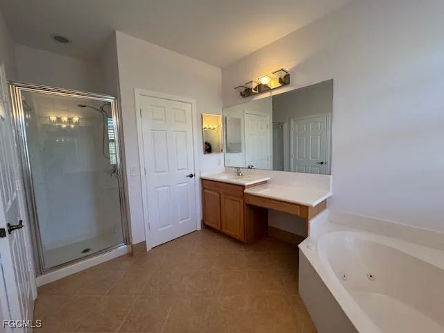 a bathroom with a tub a double vanity sink and mirror