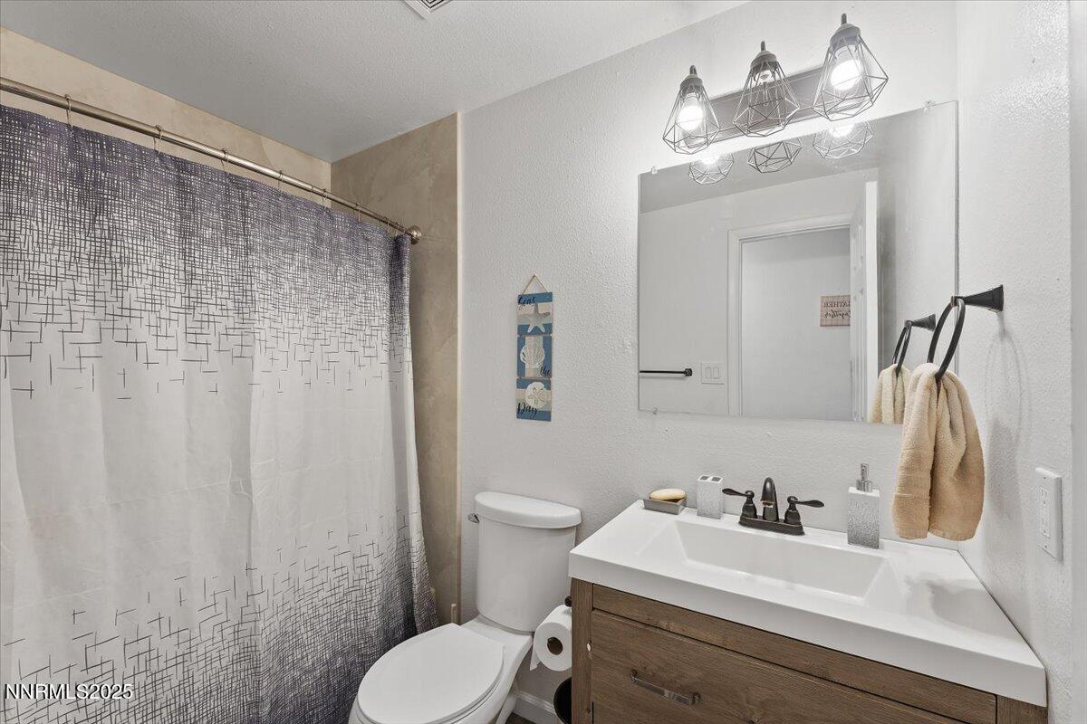 11720 Oregon Boulevard Reno, NV 89506 - Photo 12 of 45 a bathroom with a sink a toilet and shower curtain