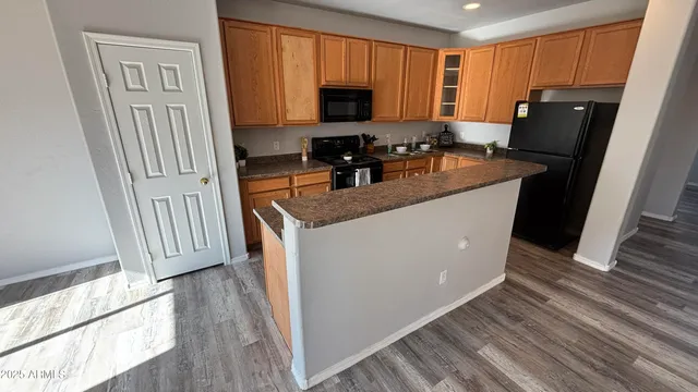 a kitchen with granite countertop a refrigerator a stove a sink and a microwave