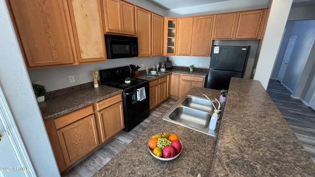 a kitchen with granite countertop a stove refrigerator and microwave