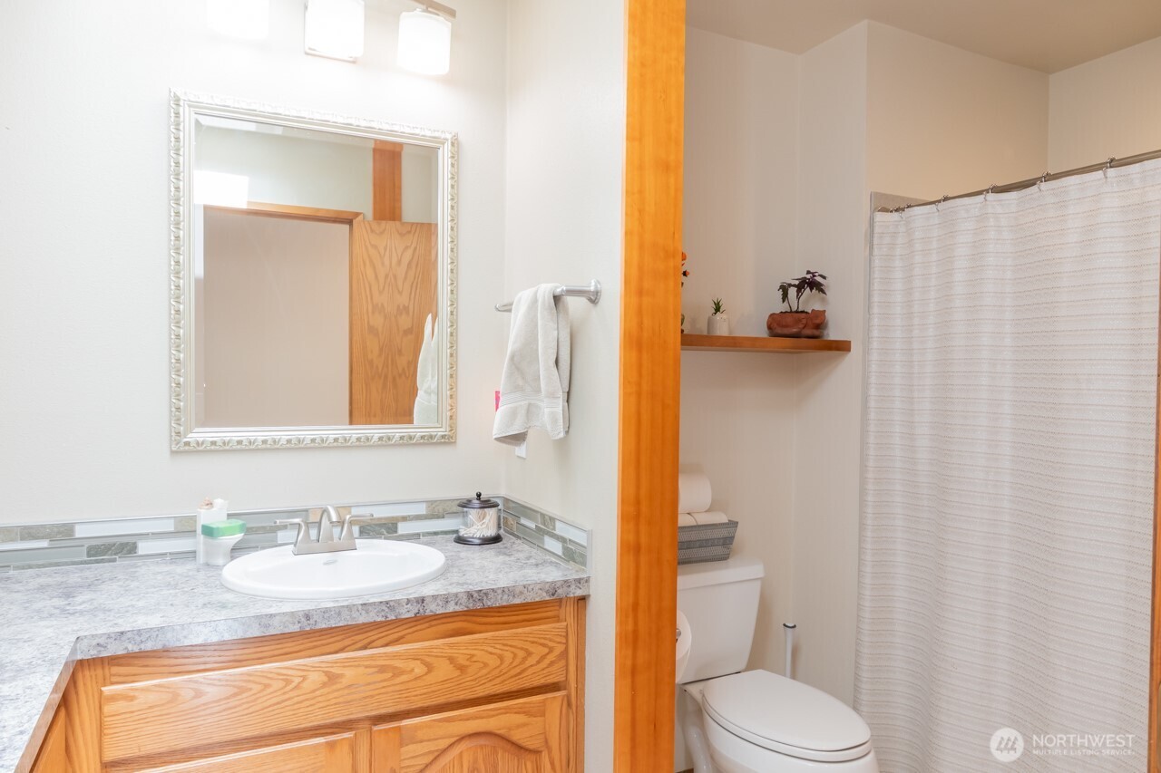 492 Walkabout Way Port Angeles, WA 98363 - Photo 26 of 40 a bathroom with a granite countertop sink toilet and mirror
